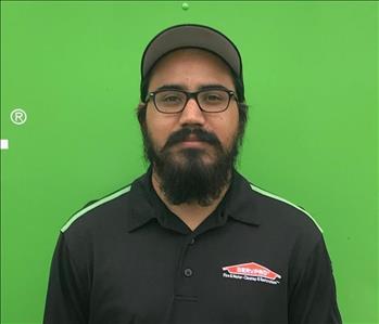 Man in black shirt in front of green background